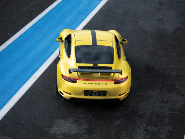 yellow porsche car on a racetrack