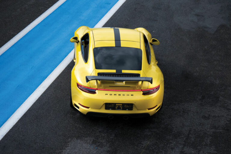 yellow porsche car on a racetrack