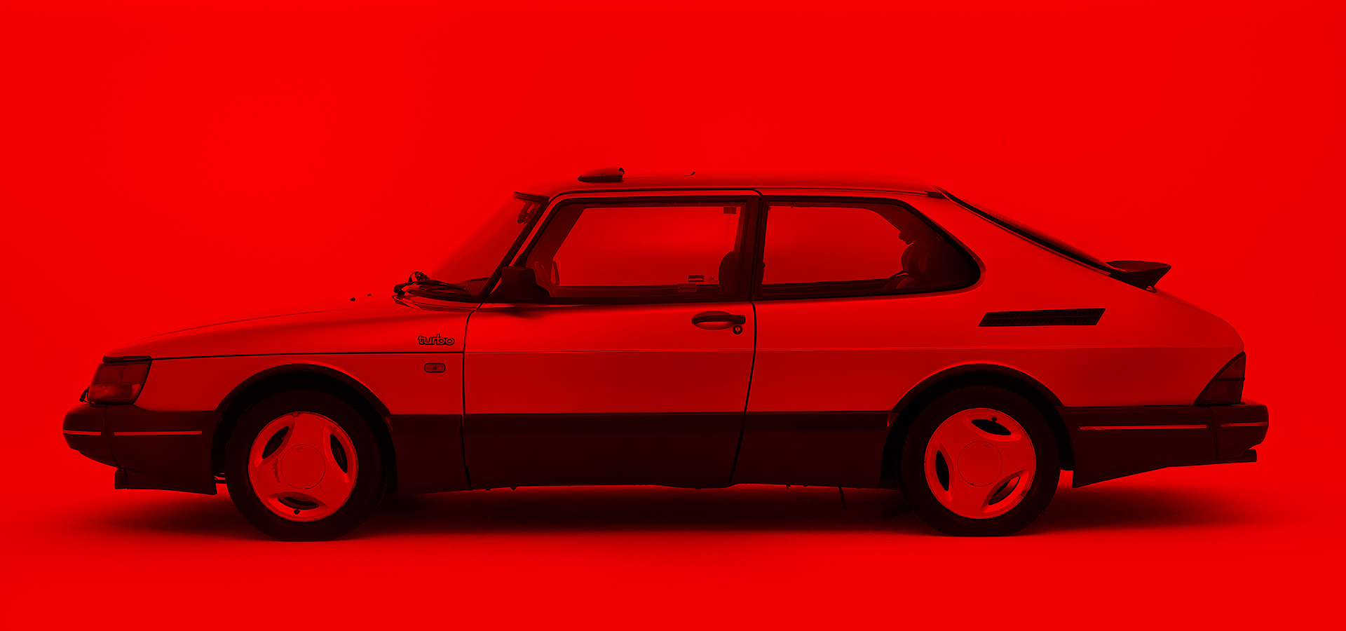 saab car seen side on over a red background